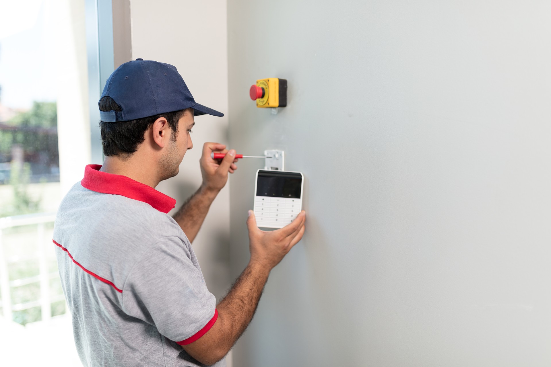 Man installing security alarm system