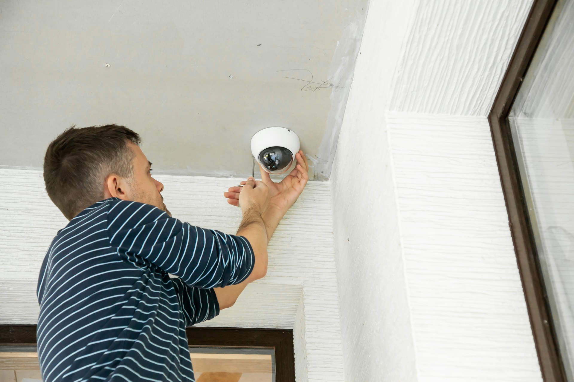 Man installs security camera in private house under construction